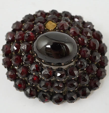 A Victorian yellow metal and garnet cluster set oval brooch (one stone lacking), 35mm. Condition - poor